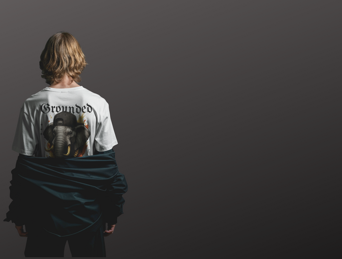 Person wearing a white Urban Jungle t-shirt with an elephant graphic design on the back against a dark background