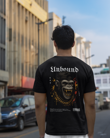 Person wearing a black t-shirt with 'Unbound' monkey design on a city street