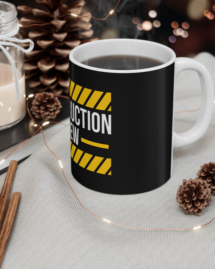 Black mug with 'CONSTRUCTION CREW' design on a table with decorative items