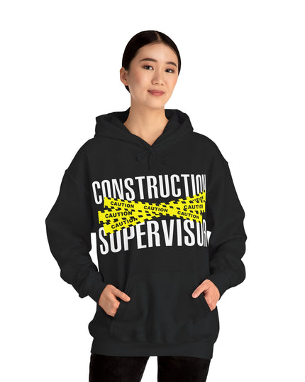 Person wearing a black hoodie with 'Construction Supervisor' text and yellow caution tape design.