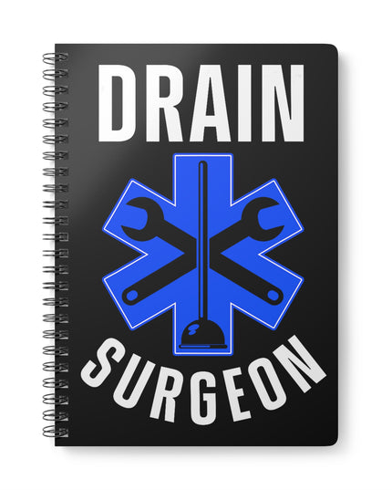 Black spiral A5 plumber notebook with "Drain Surgeon" text and a blue medical cross graphic that include plumbing tools, on a white background