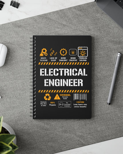 Notebook with 'Electrical Engineer' design on a desk with a pen and earbuds.
