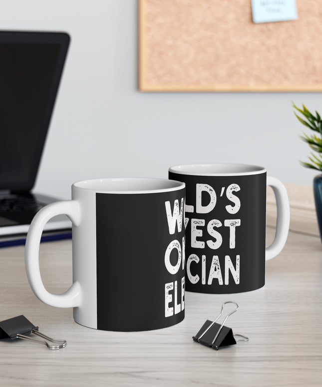 Two black mugs with white text on a desk with office supplies and a plant.